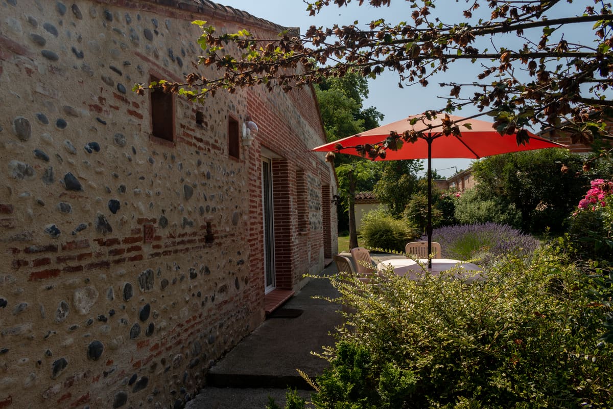 Mur en galets et coin ombragé sous le parasol